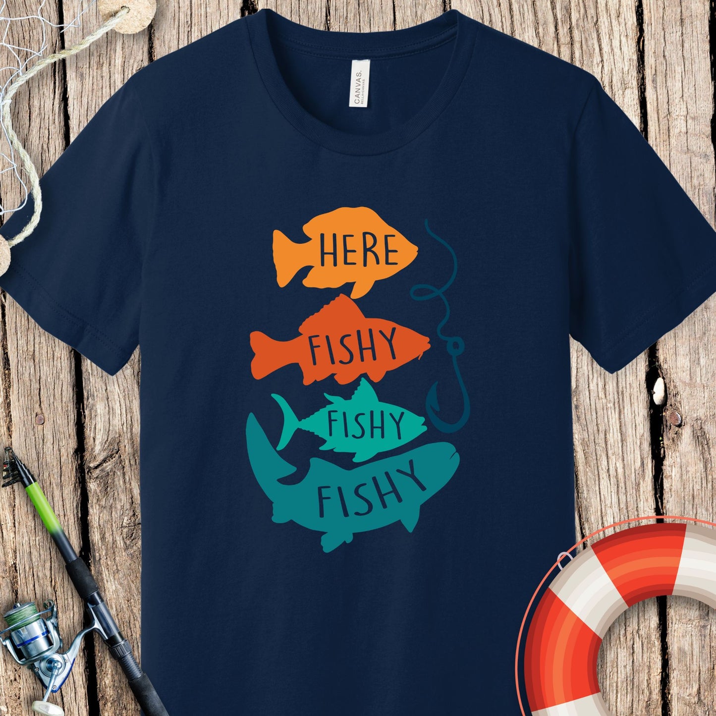 Navy blue fishing t-shirt by Printify with colorful fish and the text Here Fishy Fishy Fishy